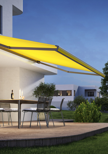 Yellow motorised awning providing shade for outdoor dining area